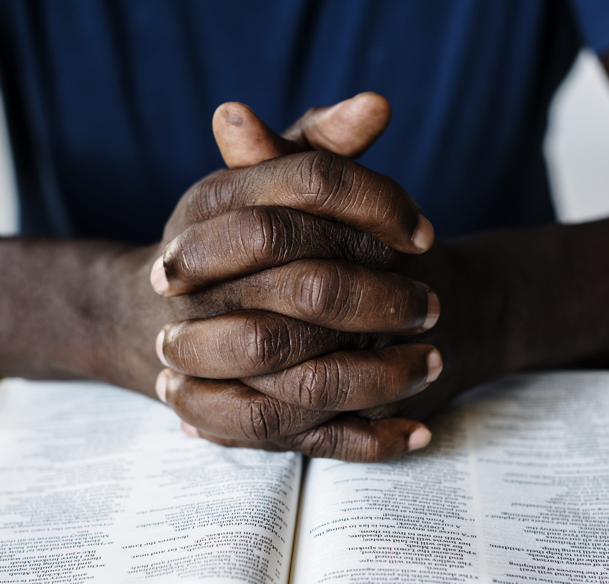 Hands resting on an open Bible